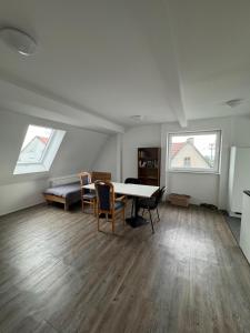 a living room with a table and chairs and two windows at 4 Schlafzimmer, Nahe Flughafen und Messe Stuttgart in Filderstadt