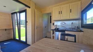a kitchen in a tiny house with a large window at La cachette du Jura in Bois-dʼAmont