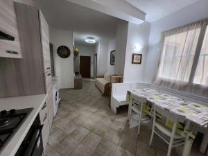 a kitchen and living room with a table and a couch at Vico Sant Erasmo Alassio in Alassio