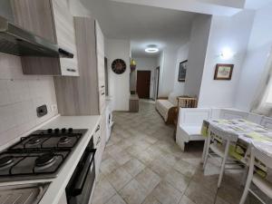 a kitchen with a stove and a living room at Vico Sant Erasmo Alassio in Alassio +5 photos