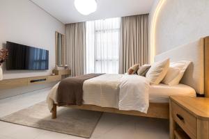 a bedroom with a large bed and a television at District One Dubai Lagoon View Near Downtown in Dubai