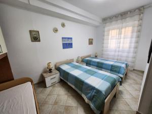 a bedroom with two beds and a night stand at Vico Sant Erasmo Alassio in Alassio