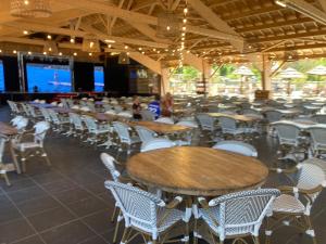 a dining room with tables and chairs and a screen at Mobil Home 6 personnes in Biscarrosse