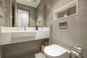 a bathroom with a sink and a toilet and a mirror at District One Dubai Lagoon View Near Downtown in Dubai +17 photos