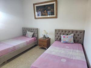 two beds sitting next to each other in a bedroom at Appartement Djerba, séjour in Djerba +6 photos
