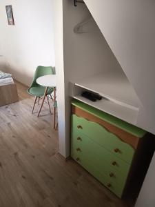 a room with a green dresser and a table at Draga studio apartment pets welcome in Draga Bašćanska