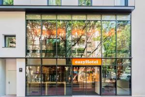 um edifício de escritórios com uma grande fachada de vidro em easyHotel Barcelona La Sagrera em Barcelona mais 51 fotografias