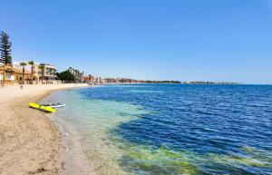 a yellow boat sitting on the shore of a beach at Villa Palmera in Las Casicas