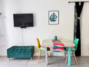 a dining room with a table and chairs and a tv at Ocean Lovers Taganga - PADI Dive Center & Hostel in Taganga