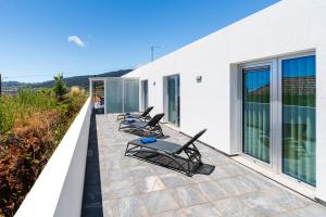 una fila de tumbonas en un balcón en Casa Alan by Rent2u, Lda, en Arco da Calheta