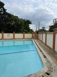 a large swimming pool next to a wall at MoDi's Seaside Nest in Mombasa