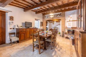 una cucina e una sala da pranzo con tavolo e sedie di Villa Soli - Casa in Pietra con Piscina Panoramica a Sassorosso