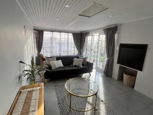 Una sala de estar con un sofá negro y un televisor. en 17onSheerness in East London Green Belt, en East London