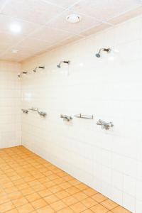 a bathroom with white tile walls and silver sinks at Valtu Spordimaja 