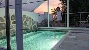 una mujer parada junto a una piscina con un perro en Casa de Madera del Turullote, en Écija
