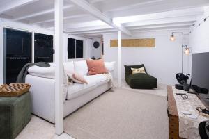 a living room with a white couch and a chair at The Point in Innisfail +7 photos