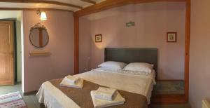 ein Schlafzimmer mit einem Bett, auf dem zwei Handtücher liegen in der Unterkunft Nar Bağevi in Bozcaada + 22 Fotos