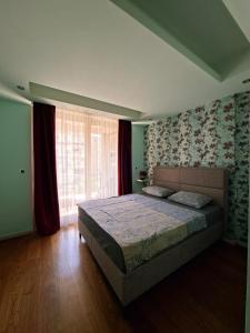 Un dormitorio con una cama y una ventana grande. en Cozy City Center Studio, en Babalonija