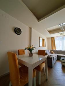 Una sala de estar con una mesa y sillas blancas. en Cozy City Center Studio, en Babalonija