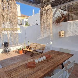 a patio with a wooden table and chairs at Lavadeira's House in Olhão