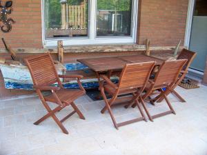 a wooden table and chairs on a patio at Pension Wendler in Bedburg