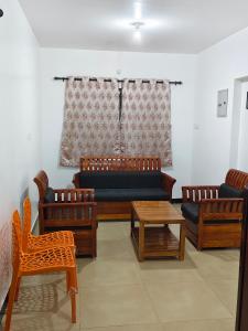 a living room with a couch and chairs and a table at shambhala homestay in Ooty