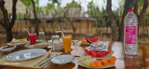 ein Holztisch mit Tellern mit Essen und einer Flasche Wasser in der Unterkunft Thumbaya Resort Yala in Tissamaharama + 56 Fotos