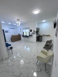 杰里科Steele honey的客厅配有沙发和椅子,位于瓷砖地板