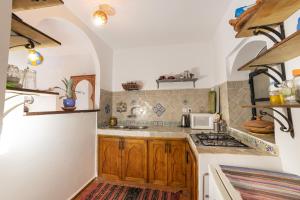 a kitchen with a stove and a microwave at Dar Yamina Andalusi in Chefchaouen