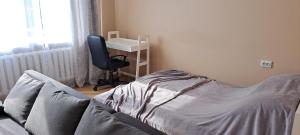 a bedroom with a bed and a desk and a chair at Stay near lake and sauna center in Abja-Paluoja