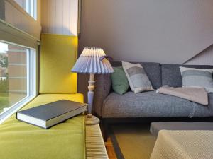 a living room with a couch with a lamp and a book at Paula - gemütliche Maisonette auf Fehmarn in Fehmarn