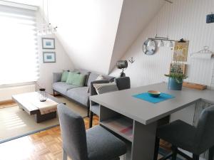 un salon avec une table et un canapé dans l'établissement Paula - gemütliche Maisonette auf Fehmarn, à Fehmarn