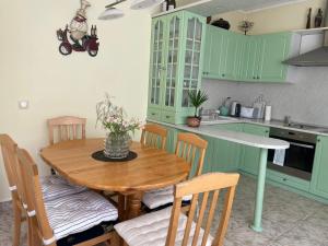 a kitchen with green cabinets and a wooden table and chairs at Apartment Maddie in Teteven