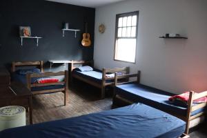 a room with three bunk beds and a guitar at Republica Do Arco Da Velha in Ouro Preto