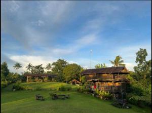 a building with a picnic table in a field at Johanna's Farm in Inabanga
