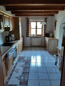 a large kitchen with a tile floor and a window at Ferienhaus Piller in Viechtach +26 photos