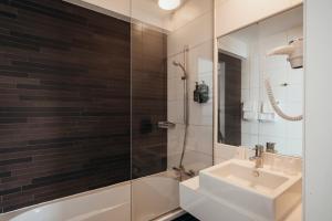 a bathroom with a sink and a shower at Hotel Ecu in Genk