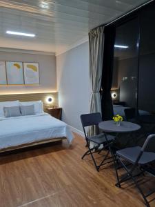 a bedroom with a bed and a table and chairs at Ooni Hostel Moalboal in Moalboal