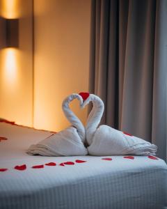 two towel swans making a heart on a bed at Hotel Ecu in Genk