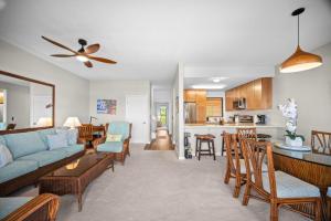 ein Wohnzimmer mit einer blauen Couch und einer Küche in der Unterkunft Makanui 221 in Kipu