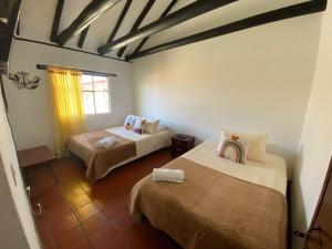 ein Zimmer mit zwei Betten und einem Fenster in der Unterkunft Apartamento Eucalyptus in Villa de Leyva
