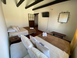 ein Hotelzimmer mit zwei Betten und einem Spiegel in der Unterkunft Apartamento Eucalyptus in Villa de Leyva + 12 Fotos