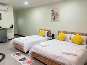 two beds sitting next to each other in a room at Muttafa House in Nai Yang Beach