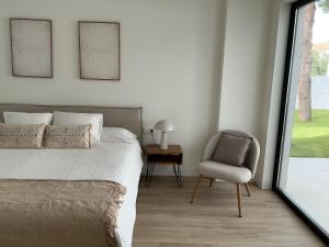 a bedroom with a bed and a chair and a window at Esmeralda Sea Villa - Beach&Golf Sancti Petri in Novo Sancti Petri +32 photos