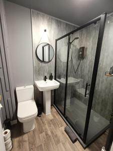 a bathroom with a shower and a toilet and a sink at Central City Apartment - Inverness centre in Inverness