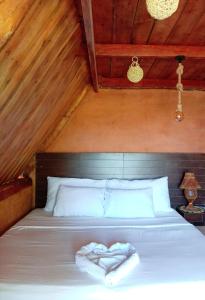 a bed with a heart shaped pillow on it at Ella Shia Cabana in Badulla