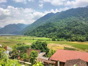 a view of a village with mountains in the background at Nam Pé Tày Homestay - View hồ Ba Bể in Bak Kan +133 photos