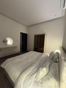 - une chambre avec un grand lit blanc dans l'établissement شقة مفروشة فاخره, à Hafr Al Baten
