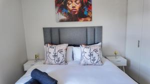 a bedroom with a bed with a painting on the wall at Apartment in uMhlanga The Millennial in Durban