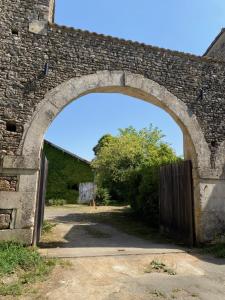 an arch in a brick wall with a gate at Le Clos de l'Herbaudière in Saivres